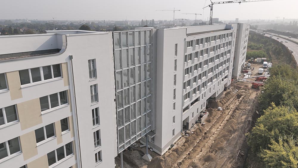 23 Meter hohe Lärmschutzwand aus Glas zwischen Wohngebäuden RAU Vista