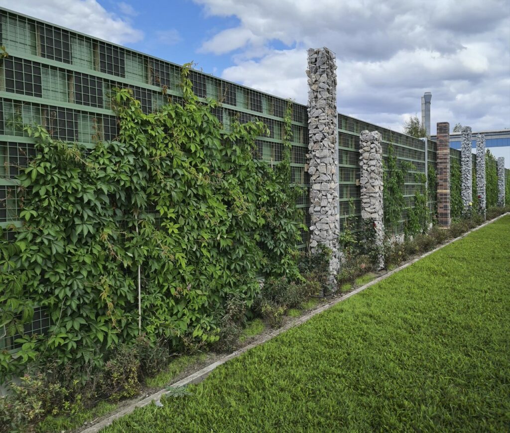rau-noiseguard-green-Moderne-Schallschutzwand-mit-begruenten-Gittern-entlang-einer-gruenen-Rasenflaeche